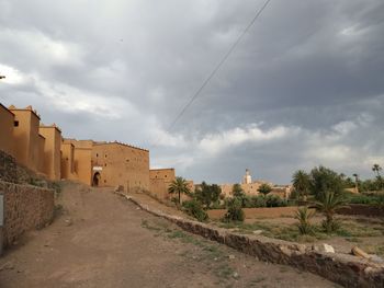 Road amidst buildings against sky