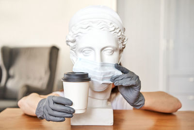 Midsection of man holding white candle on table