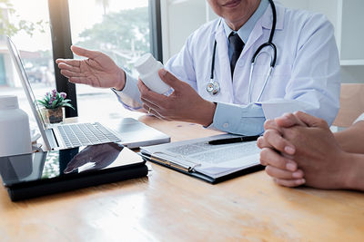 Midsection of man using laptop on table