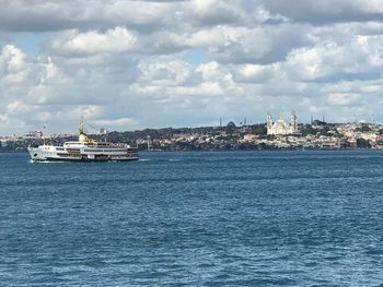 Ship in sea against cloudy sky