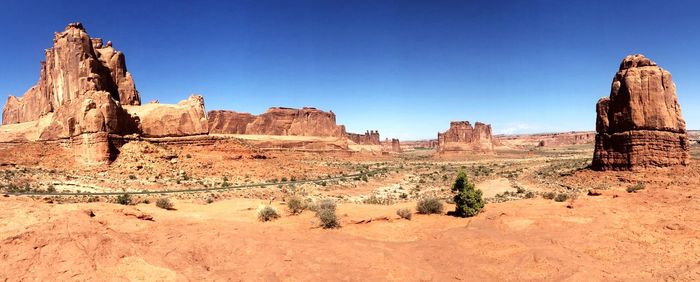 Panoramic view of rock formations against blue sky