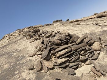 Low angle view of rocks on land against sky