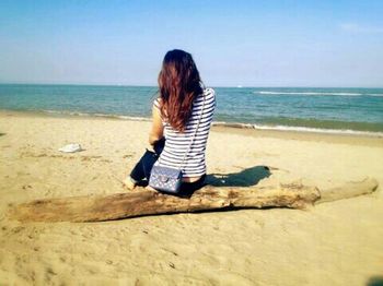 Rear view of woman standing on beach