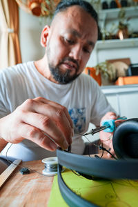 Repairing electronic circuit board inside headphones with soldering iron at home. diy project.