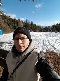 Portrait of young man standing on snow field