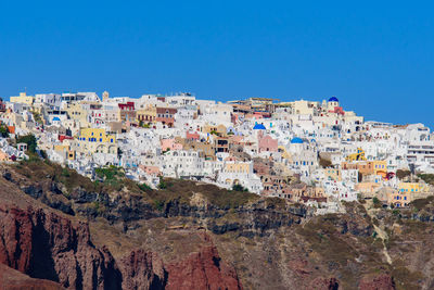 View of buildings in city against clear blue sky