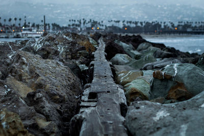 Close-up of rocks by river against sky