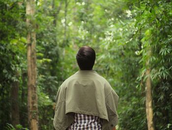 Rear view of man standing in forest