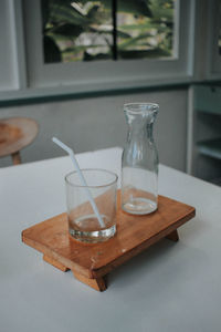 Drinking glass and bottle on table