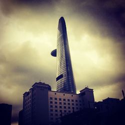 Low angle view of modern buildings against cloudy sky