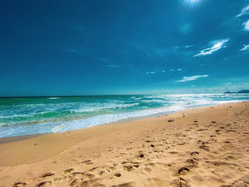 Scenic view of beach against blue sky