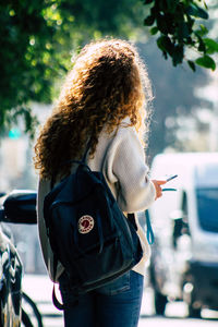 Rear view of woman with umbrella in city