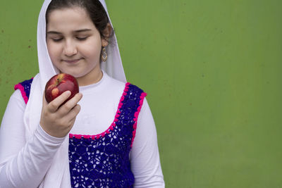 Portrait of a smiling girl holding apple