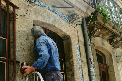 Rear view of man standing against building