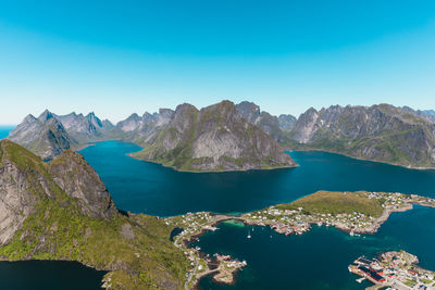 Panoramic view of sea and mountains against clear blue sky