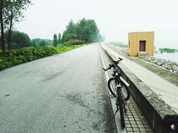 Bicycle on road against clear sky