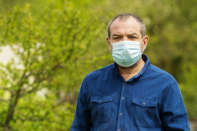 Adult male allergic person in a protective mask on nature