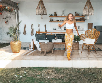 Woman sitting on chair against plants