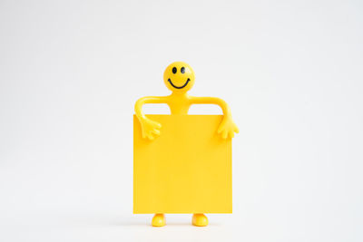 Close-up of yellow toy over white background