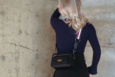 Rear view of woman standing against wall