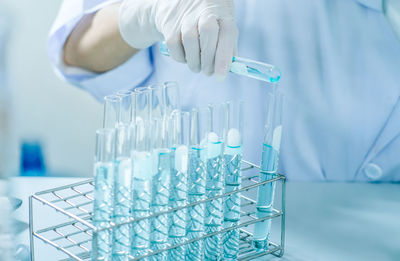 Close-up of person holding test tubes