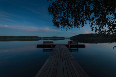 Pier over lake against sky during dusk