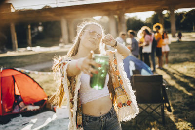 Midsection of woman holding ice cream standing outdoors