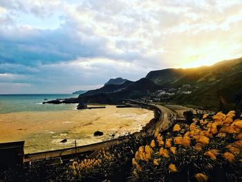 Scenic view of beach against cloudy sky