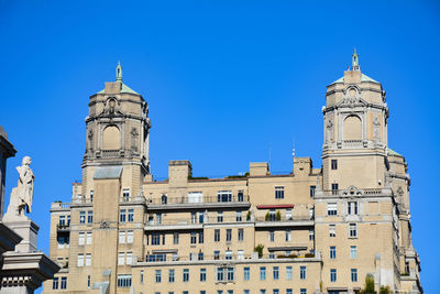 Low angle view of clock tower against clear blue sky