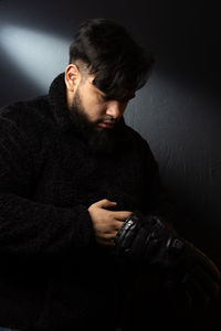 Young woman looking away against black background