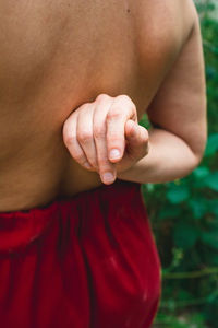 Rear view of shirtless woman standing outdoors