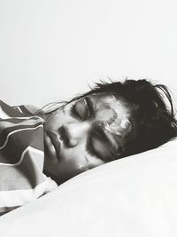 Close-up of girl with paint on her face sleeping on bed