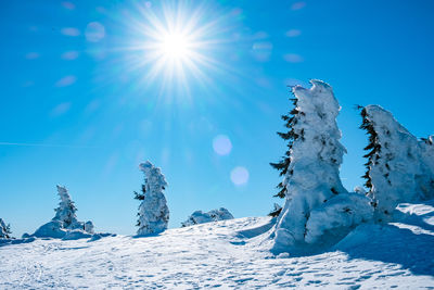 Scenic view of snowcapped mountains against blue sky on sunny day