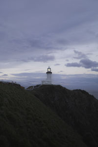 Lighthouse by sea against sky