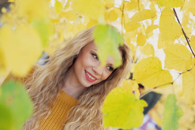 Portrait of young woman with yellow leaves