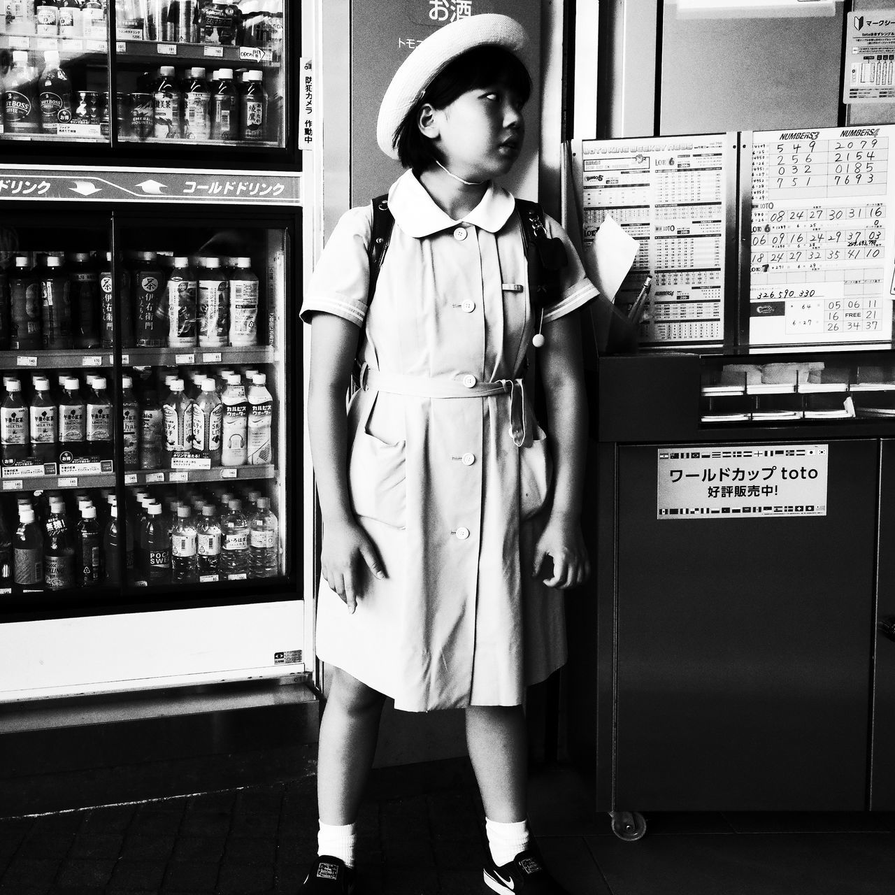 real people, one person, full length, front view, standing, indoors, child, childhood, lifestyles, food and drink, casual clothing, girls, looking, boys, women, store, leisure activity, retail, innocence, uniform, vending machine