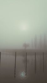 Scenic view of lake against sky during foggy weather