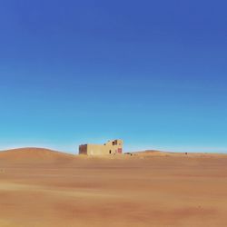 Scenic view of desert against clear blue sky