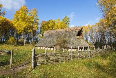 Bronze age longhouse on a meadow with a branch fence