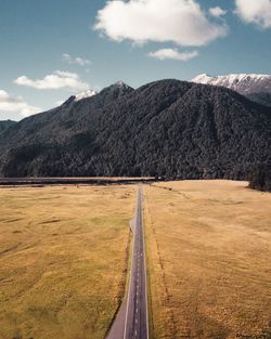 Road leading towards mountains against sky