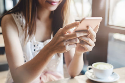 Midsection of woman holding coffee cup