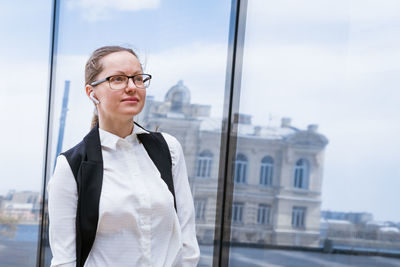 Portrait happy business woman who looks confident in a suit and glasses stands