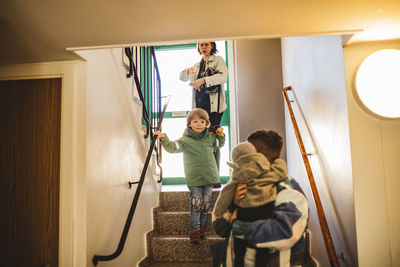 Parents with children walking down staircase