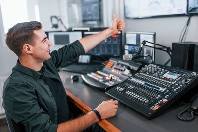 Setting the equipment. young man is indoors in the radio studio is busy by broadcast.