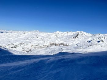 Scenic view of snowcapped mountains against clear blue sky