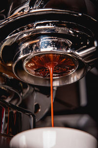 Close-up of coffee pouring in cup