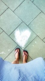 Low section of woman standing on tiled floor