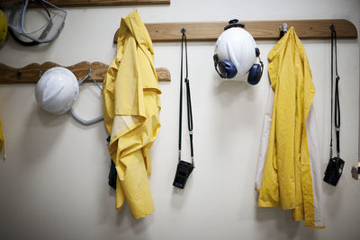 Protective workwear hanging from coat hooks