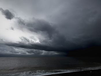 Scenic view of sea against storm clouds