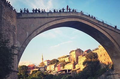 Low angle view of arch bridge and buildings against sky